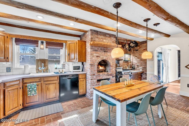 kitchen with arched walkways, a sink, decorative backsplash, light countertops, and dishwasher