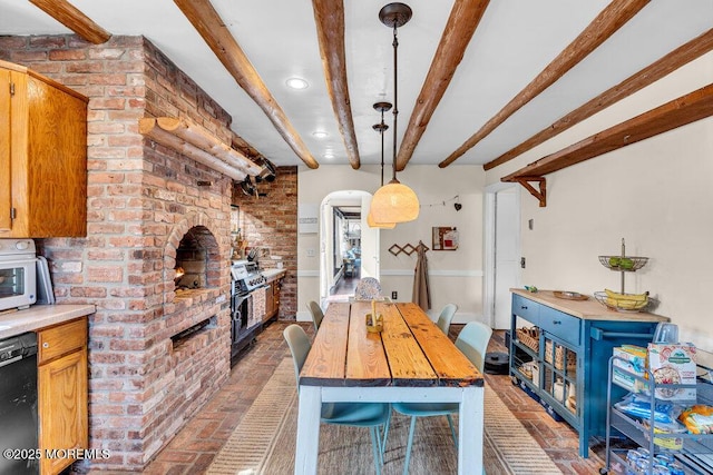 dining space with brick wall, beam ceiling, recessed lighting, arched walkways, and brick floor