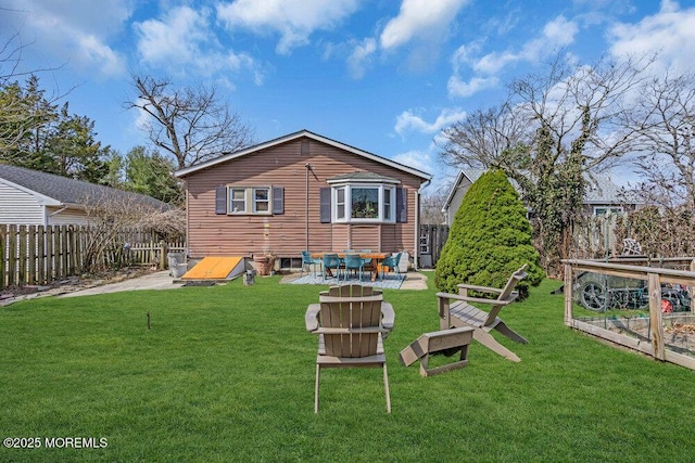 rear view of house with a lawn and a fenced backyard