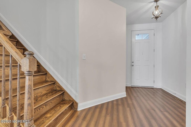 entryway with stairway, wood finished floors, and baseboards