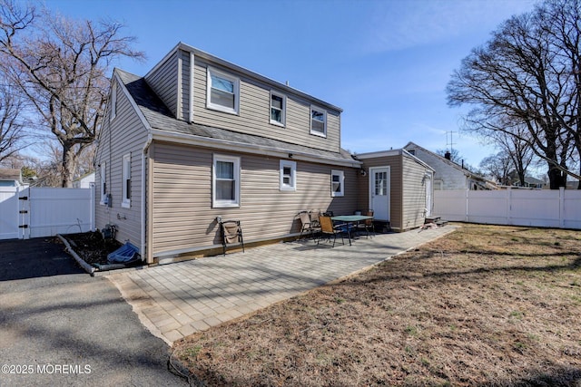 rear view of house with a patio, a gate, a fenced backyard, and a yard