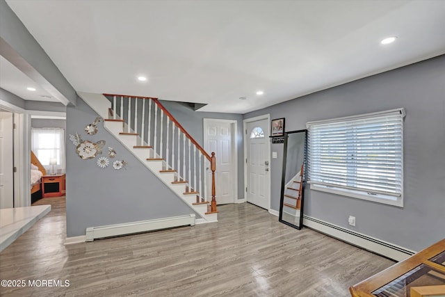 entryway featuring stairs, wood finished floors, and a baseboard radiator