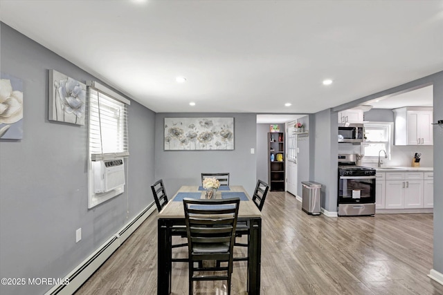 dining space featuring light wood finished floors, a baseboard heating unit, baseboards, recessed lighting, and cooling unit