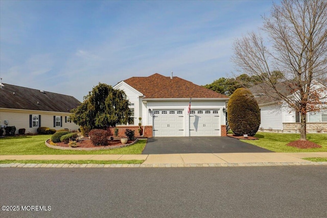 view of front facade featuring a front yard, a garage, brick siding, and driveway