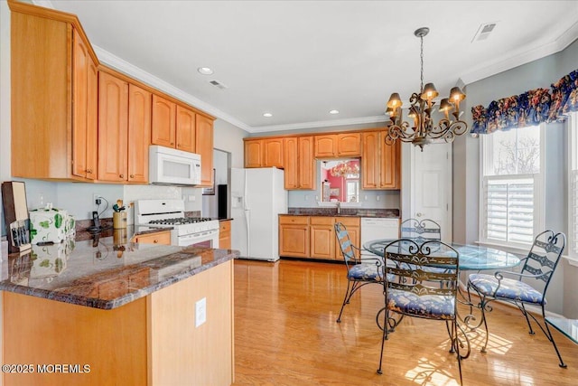 kitchen featuring visible vents, a notable chandelier, white appliances, a peninsula, and crown molding