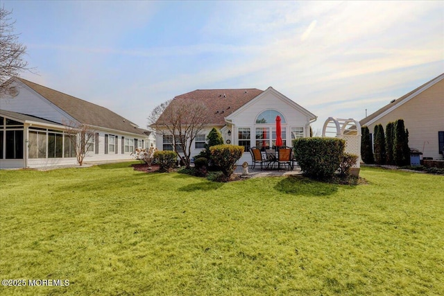 rear view of house featuring a patio and a yard