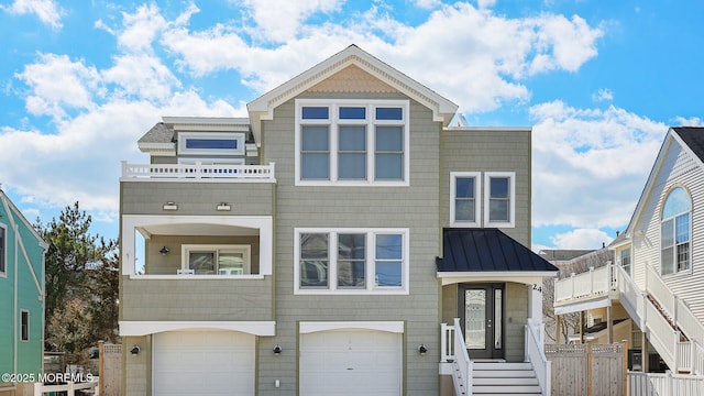 view of front of house with a standing seam roof, a balcony, fence, and metal roof