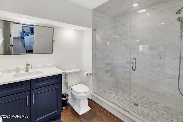 full bath with a stall shower, toilet, vanity, and wood tiled floor