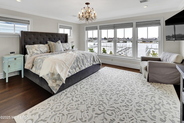 bedroom with dark wood finished floors, crown molding, visible vents, and an inviting chandelier