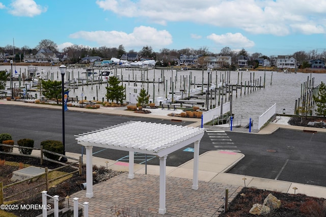 exterior space featuring a water view and a pergola