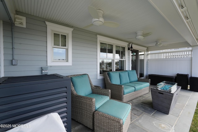 view of patio / terrace with an outdoor living space with a fire pit, a ceiling fan, and fence