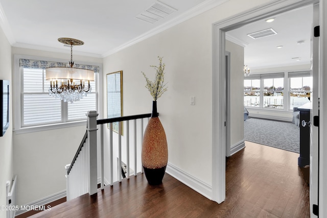 hall featuring visible vents, an upstairs landing, an inviting chandelier, and crown molding