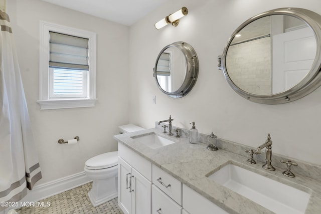 full bath with double vanity, toilet, baseboards, and a sink