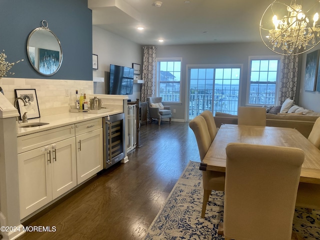 dining room with baseboards, beverage cooler, a chandelier, recessed lighting, and dark wood-style flooring