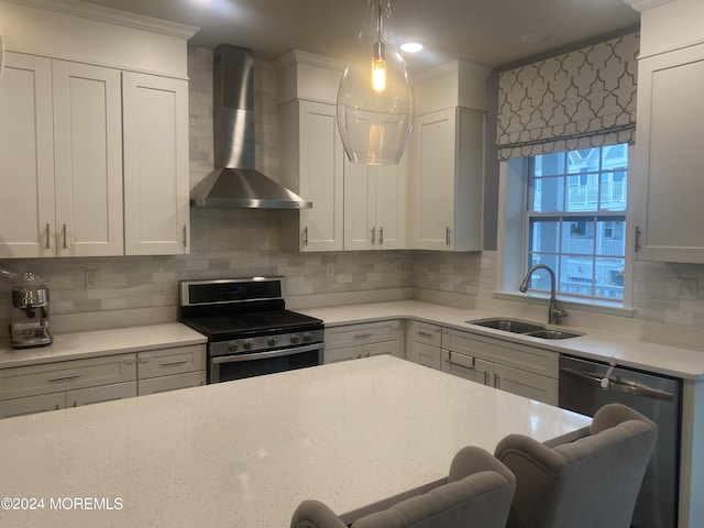 kitchen with a sink, a kitchen breakfast bar, appliances with stainless steel finishes, wall chimney exhaust hood, and decorative backsplash