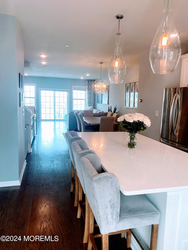 dining area featuring baseboards, dark wood-type flooring, and a healthy amount of sunlight