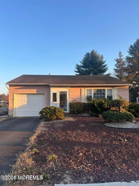 single story home featuring aphalt driveway and an attached garage