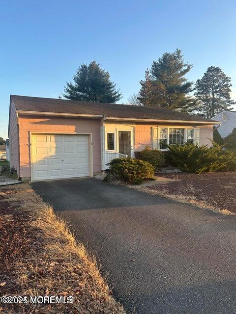 ranch-style house featuring an attached garage and driveway