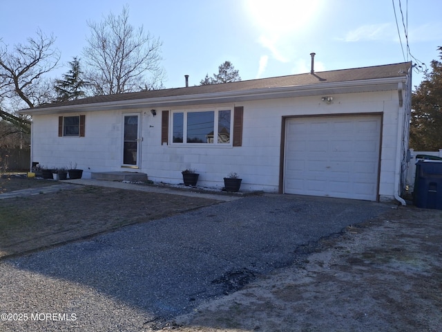 ranch-style house with aphalt driveway and a garage