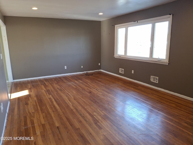 unfurnished room featuring visible vents, recessed lighting, baseboards, and wood finished floors