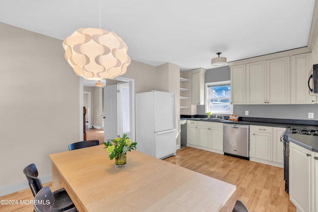 kitchen featuring open shelves, a sink, black appliances, light wood-style floors, and dark countertops