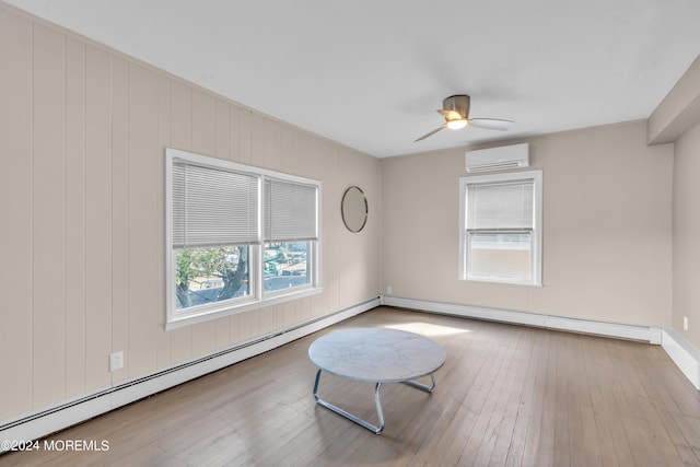 unfurnished room featuring an AC wall unit, a baseboard heating unit, hardwood / wood-style floors, a baseboard radiator, and ceiling fan