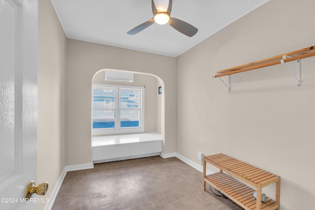 unfurnished room with a ceiling fan, a wall mounted AC, and baseboards