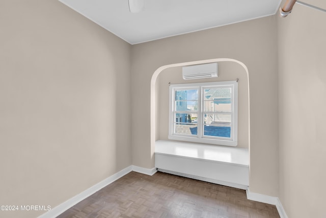 spare room with baseboards and an AC wall unit