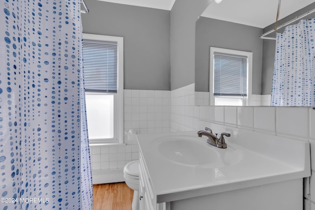 bathroom featuring curtained shower, toilet, vanity, wood finished floors, and tile walls