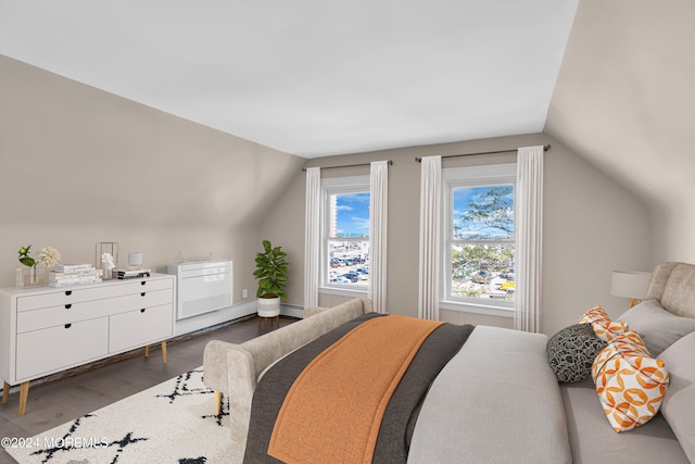 bedroom featuring a baseboard heating unit, lofted ceiling, and dark wood-style floors