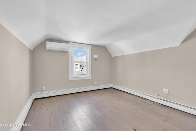 bonus room with vaulted ceiling, a wall mounted air conditioner, and hardwood / wood-style flooring