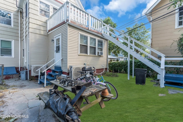 rear view of house featuring a lawn and entry steps