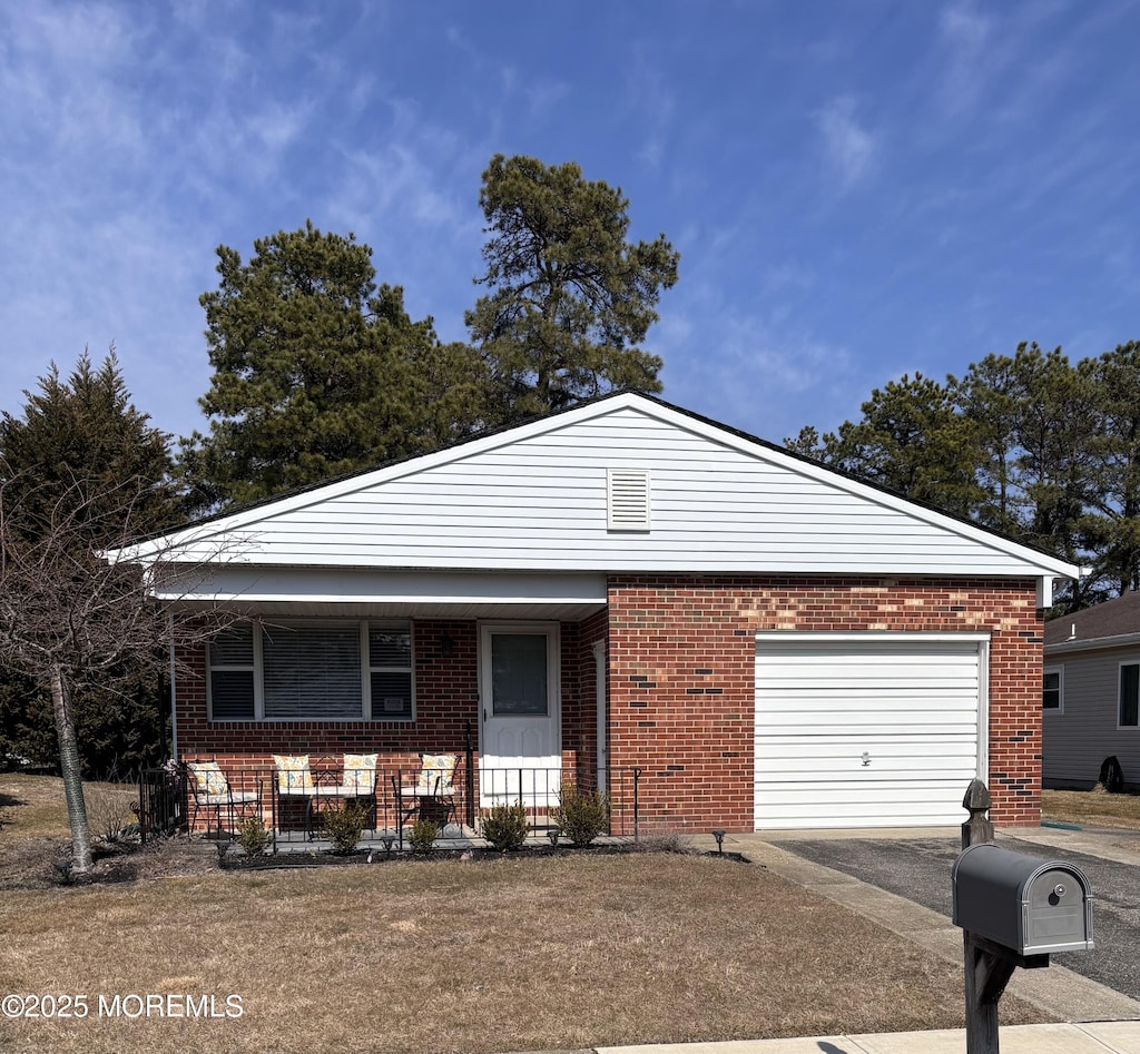 view of front of house featuring aphalt driveway, brick siding, a porch, and an attached garage