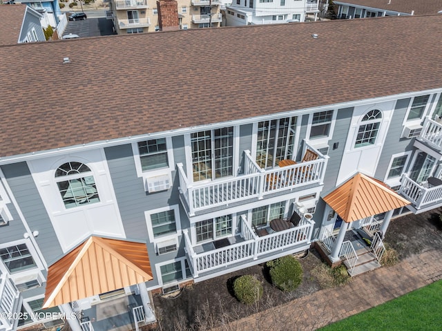 rear view of house featuring a shingled roof