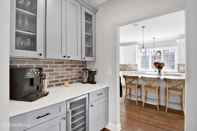 kitchen featuring wine cooler, backsplash, glass insert cabinets, and dark wood-style flooring