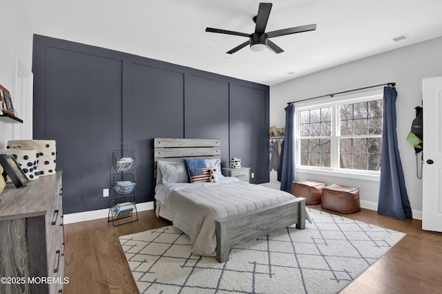 bedroom with visible vents, baseboards, and wood finished floors