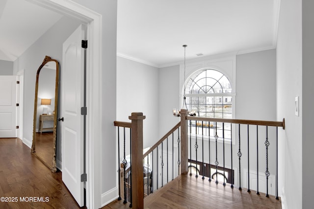 hall with baseboards, an upstairs landing, dark wood-style flooring, and crown molding