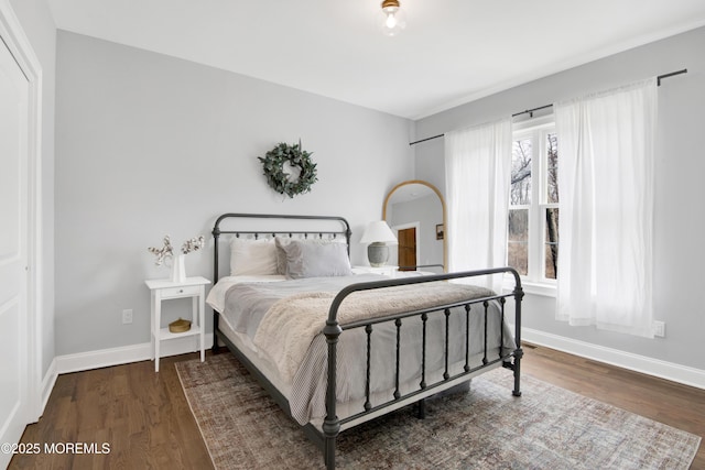 bedroom with baseboards and wood finished floors