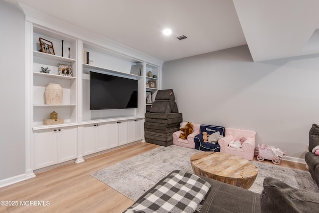 interior space featuring built in features, visible vents, baseboards, and light wood-style flooring