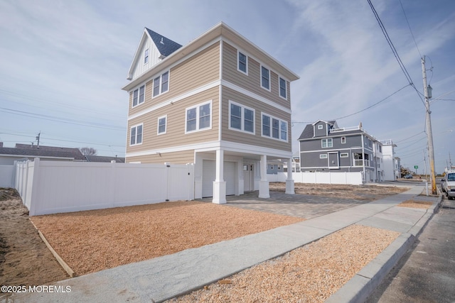 view of front of property with a garage, board and batten siding, and fence