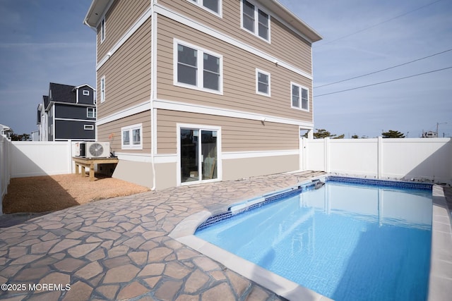 rear view of property featuring a fenced in pool, a patio, and a fenced backyard