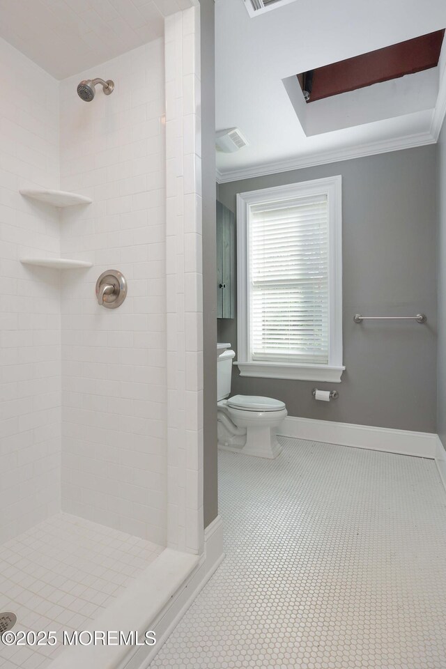full bathroom featuring baseboards, ornamental molding, toilet, and tiled shower