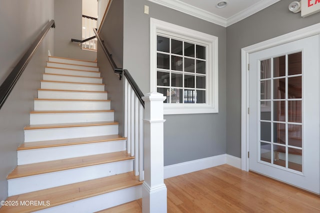 stairs with baseboards, ornamental molding, and wood finished floors