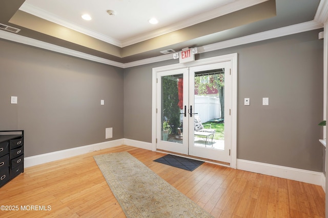 doorway featuring french doors, visible vents, baseboards, light wood-style floors, and ornamental molding