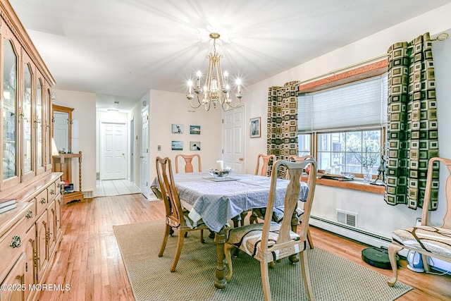 dining room featuring a notable chandelier, visible vents, and light wood finished floors