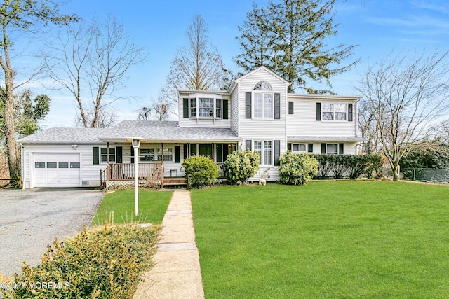 view of front of home with a front yard, an attached garage, a porch, and aphalt driveway