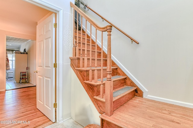 stairs featuring wood finished floors and baseboards