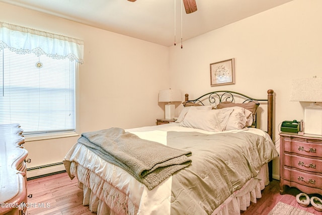 bedroom featuring a ceiling fan, wood finished floors, and a baseboard radiator