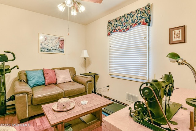 living area with a ceiling fan, wood finished floors, and visible vents