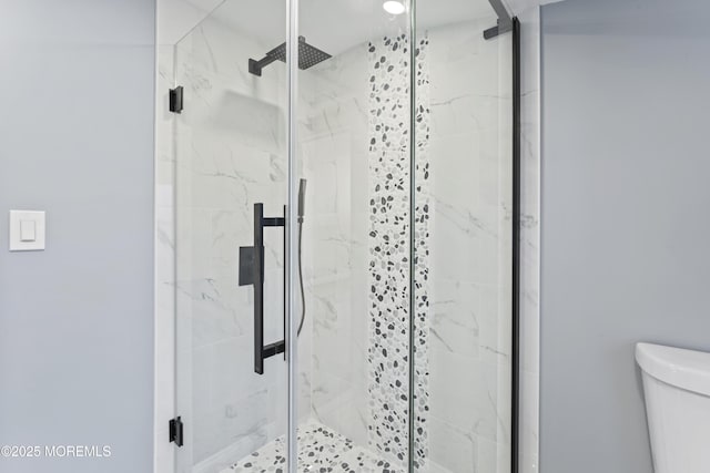 full bath with a marble finish shower and toilet